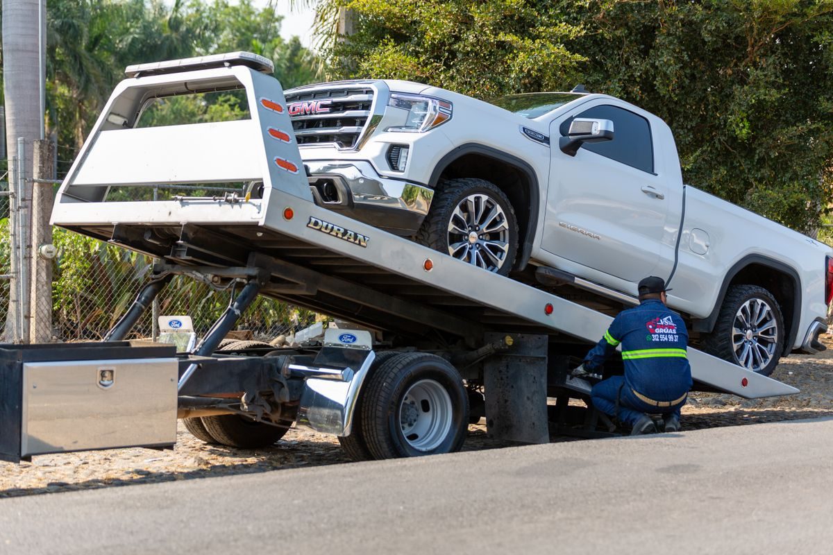 Flatbed recovery truck loading a vehicle for transport — Equipment recovery and transport in the UAE